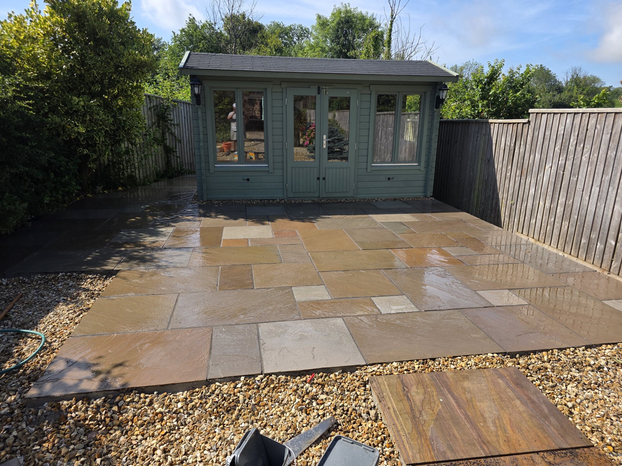 Sandstone patio leading to a garden room